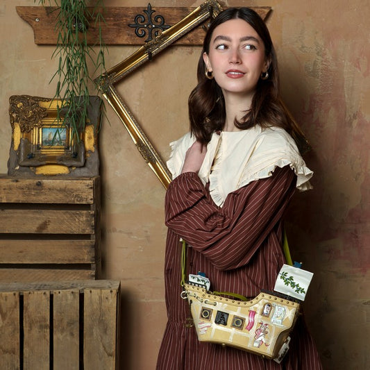 Woman in a vintage-style outfit holding a decorative bag in a rustic interior setting.