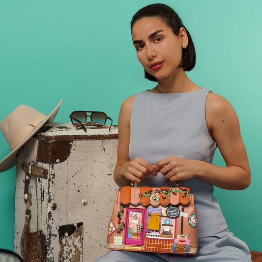 Woman holding a colorful handbag with a turquoise background
