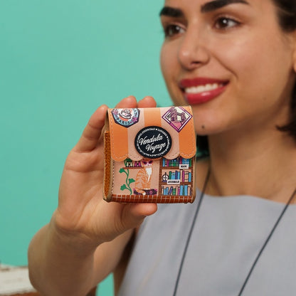 Woman holding a decorative wallet with stickers against a teal background