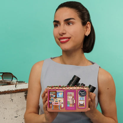 Woman holding a uniquely designed product against a teal background