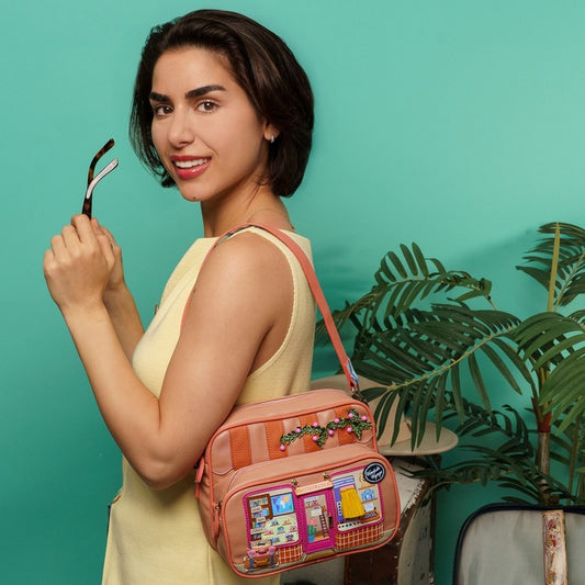 Woman holding a colorful backpack against a teal background