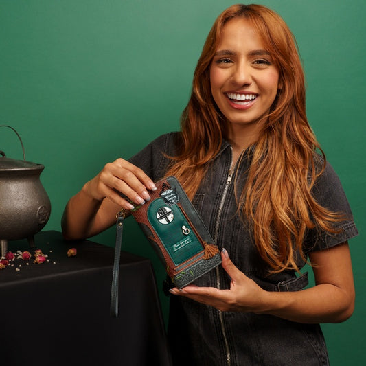 Woman holding a green leather wallet with a green background