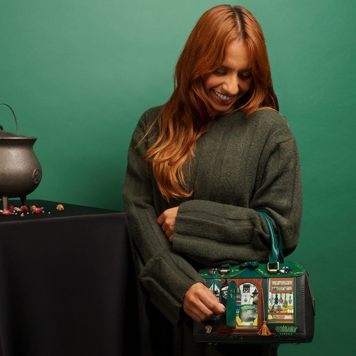 Woman holding a green handbag with decorative design against a green background