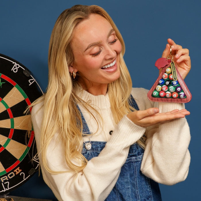 Woman holding a colorful keychain with a dartboard design against a blue background