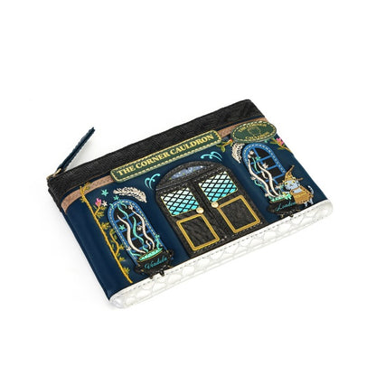 A rectangular zip pouch featuring a highly detailed, colorful embroidered illustration of 'The Corner Cribbon' storefront on a dark navy blue background, shown on a plain white background.