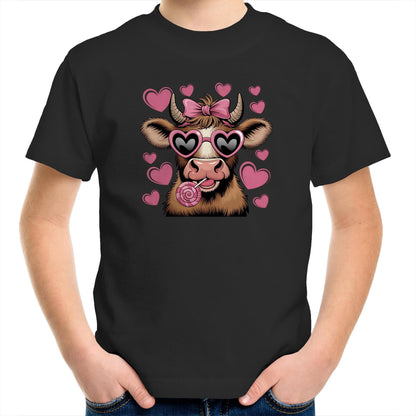 A stylized cartoon cow face with brown and cream fur, pink heart-shaped sunglasses, a pink bow on its horns, and a pink lollipop, surrounded by pink hearts on a light pink background.