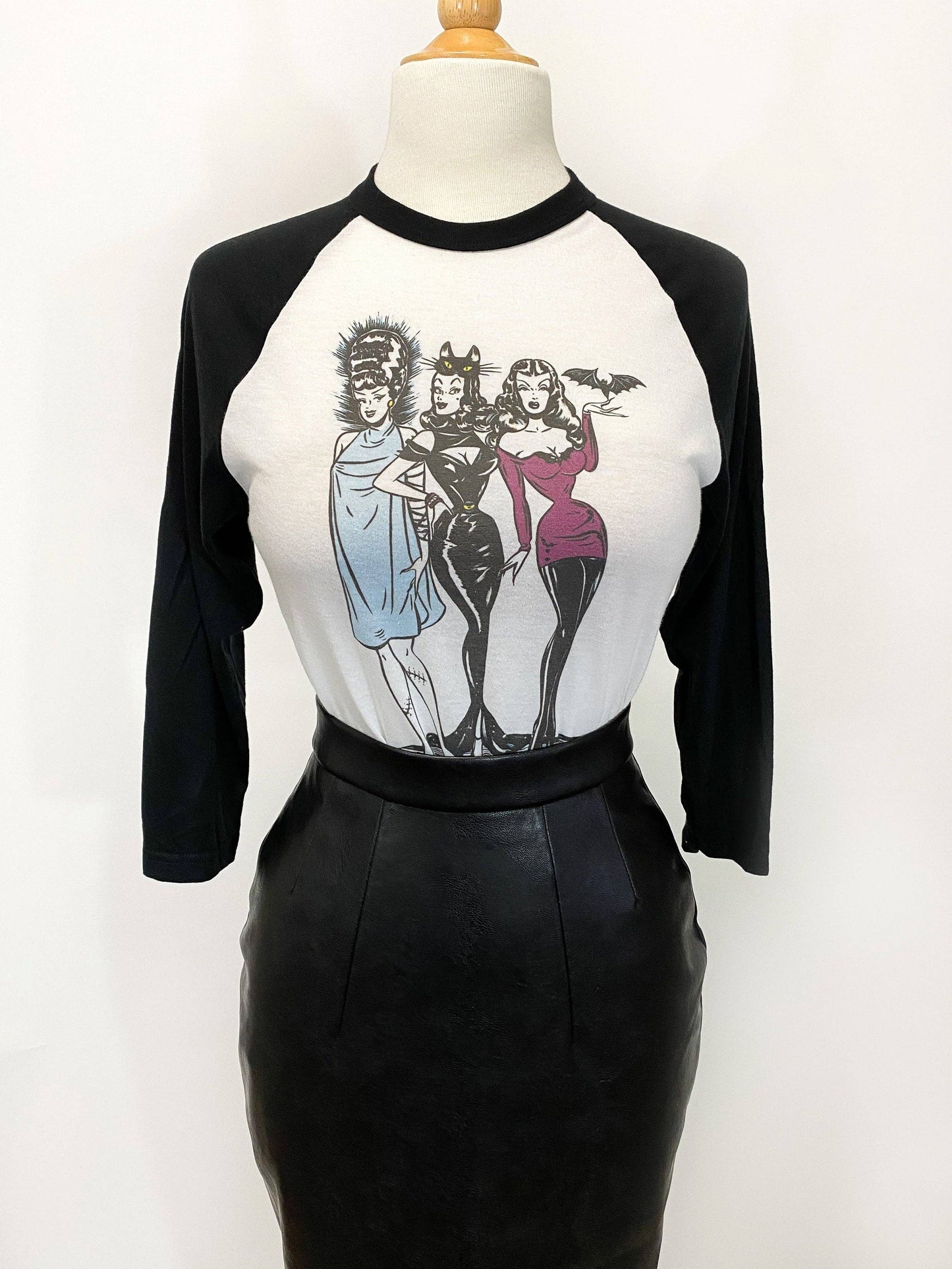 Black and white baseball shirt with graphic design on a mannequin against a white background