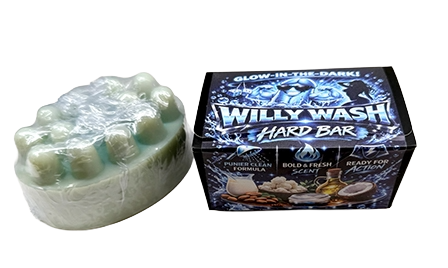 A pale mint green hard bar soap wrapped in clear plastic next to its retail box. The box is black with blue graphics and features the brand name 'Willy Wash' and scent name 'Tribula'.