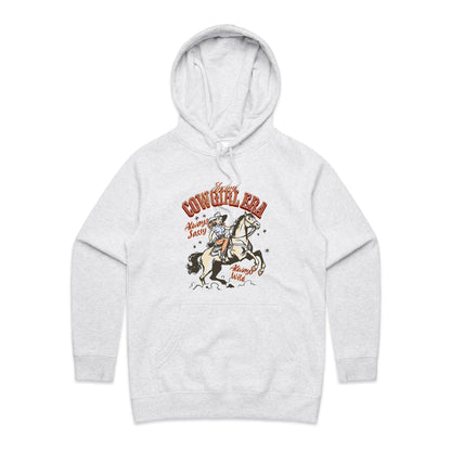 A close-up of a light heather gray hoodie featuring a vintage-style graphic of a cowboy riding a horse, with the text 'In my COWGIRL ERA Always Sassy Always Wild'.