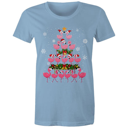 A black t-shirt featuring a festive Christmas graphic of pink flamingos stacked in the shape of a Christmas tree, wearing red Santa hats, with a green wreath, gold bells, and white snowflakes on a black background.
