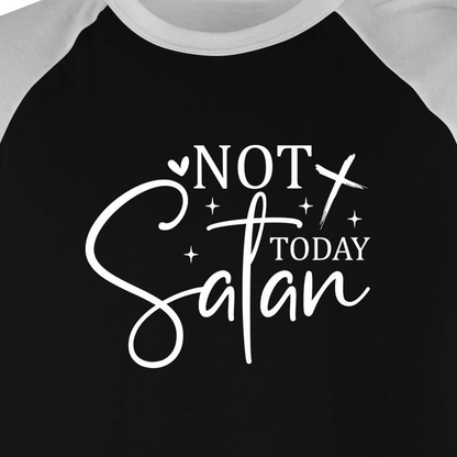 A close-up of a raglan-style baseball t-shirt featuring a black body and white sleeves, with a white graphic print on the front that reads 'NOT TODAY Satan' in stylized lettering.