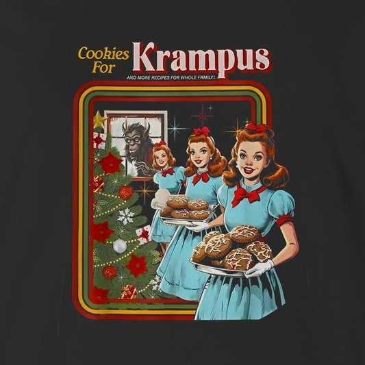 A graphic print on a dark charcoal t-shirt featuring a retro-style illustration of three women in light blue dresses carrying trays of cookies next to a decorated Christmas tree, with the text 'Cookies For Krampus' at the top.