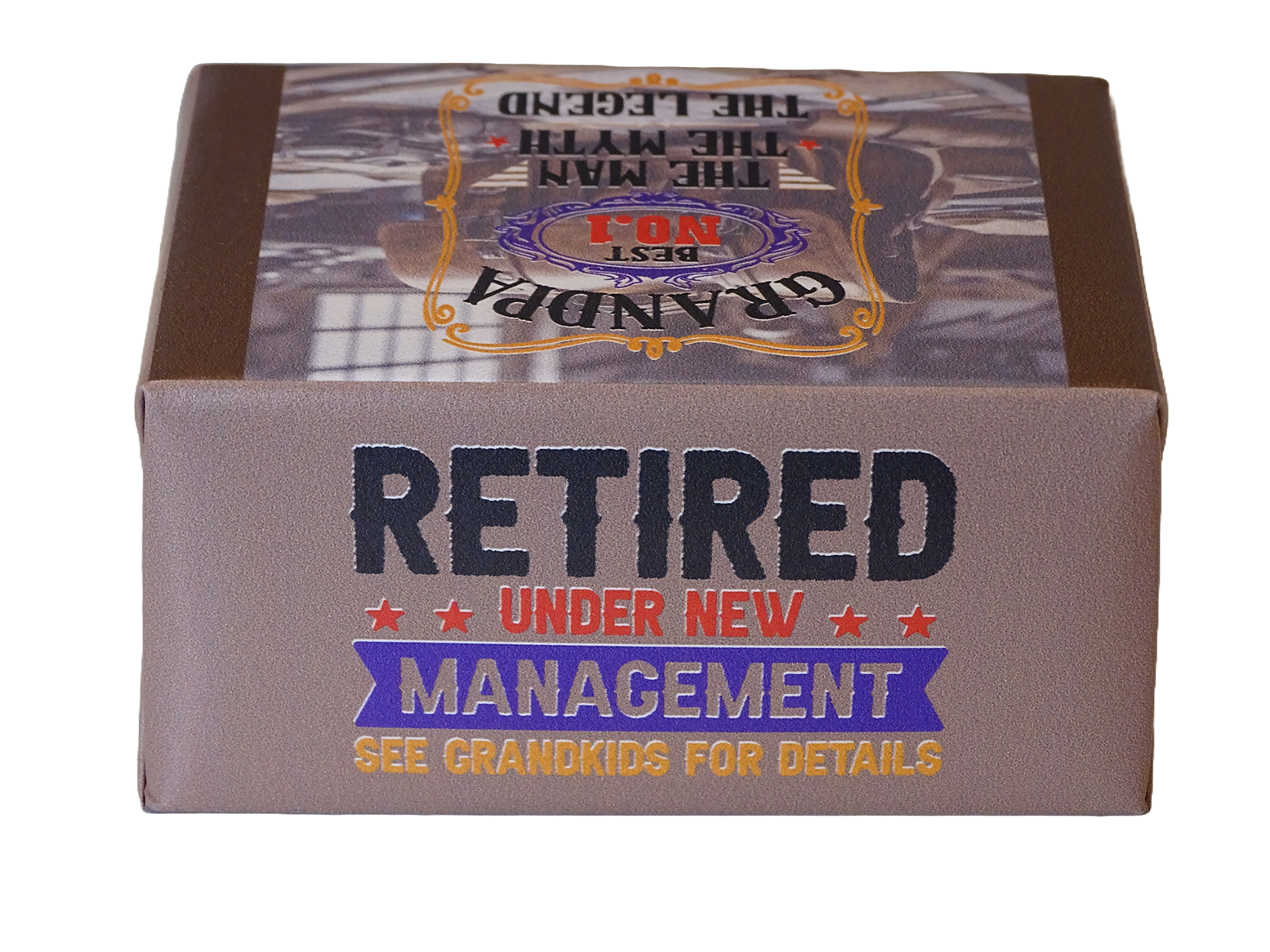 A rectangular product box with a brown and gray design, featuring the text 'RETIRED UNDER NEW MANAGEMENT' and 'SEE GRANDKIDS FOR DETAILS' on a white background.