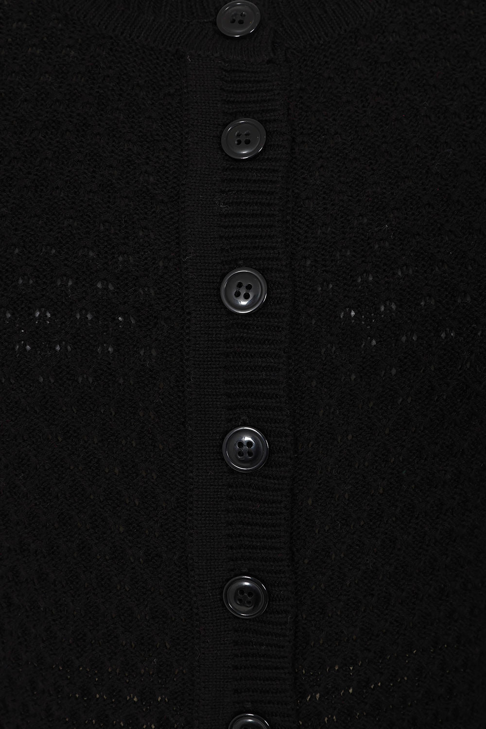 Close-up of a black textured fabric with button details