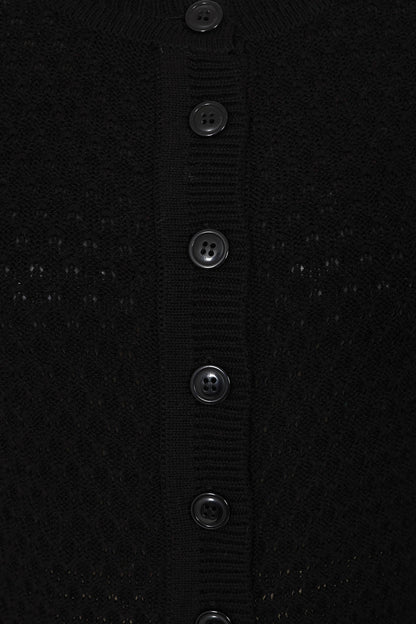 Close-up of a black textured fabric with button details