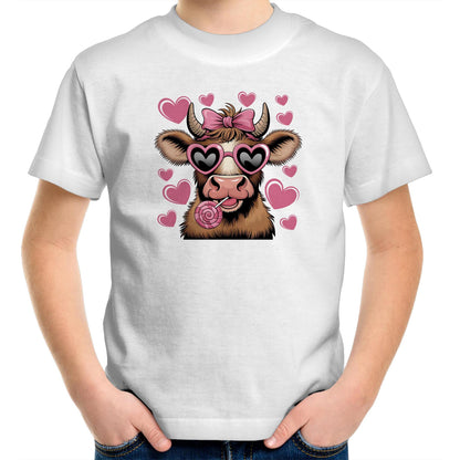 A stylized cartoon cow face with brown and cream fur, pink heart-shaped sunglasses, a pink bow on its horns, and a pink lollipop, surrounded by pink hearts on a light pink background.