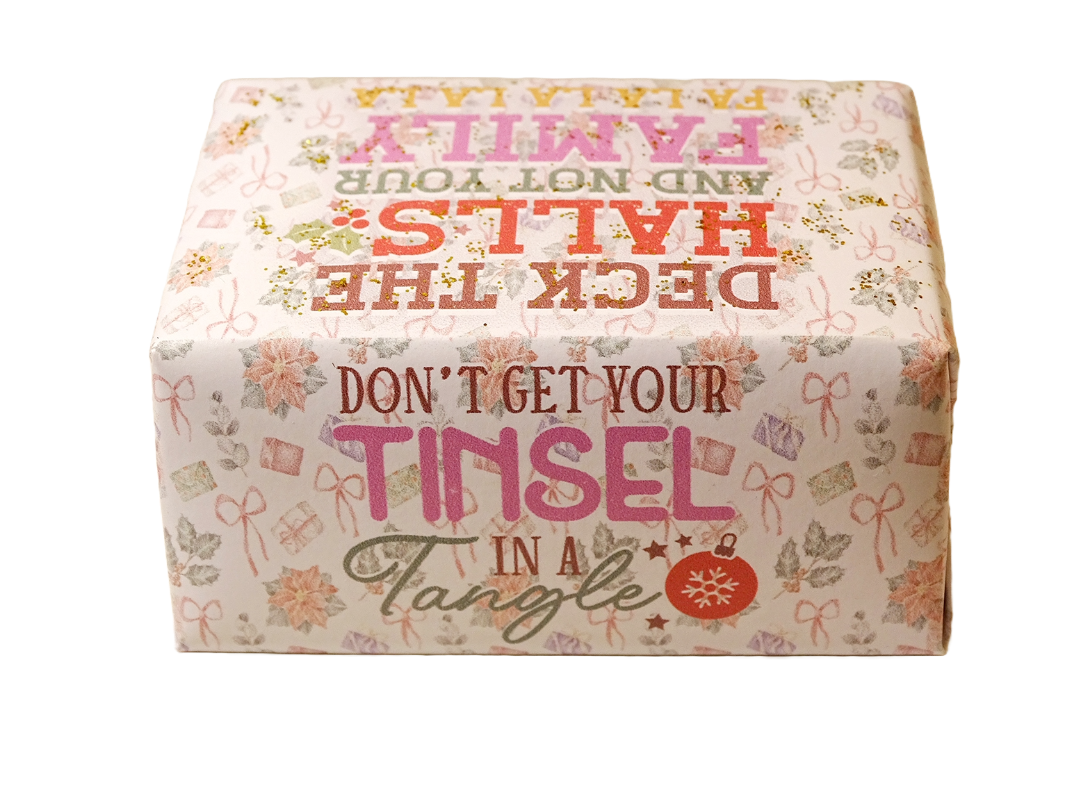 A square decorative box with a festive holiday design, featuring the text 'DON'T GET YOUR TINSEL IN A TANGLE' and 'DECK THE HALLS AND NOT YOUR FAMILY' in pink, red, and green lettering on a cream background with floral and gift motifs.