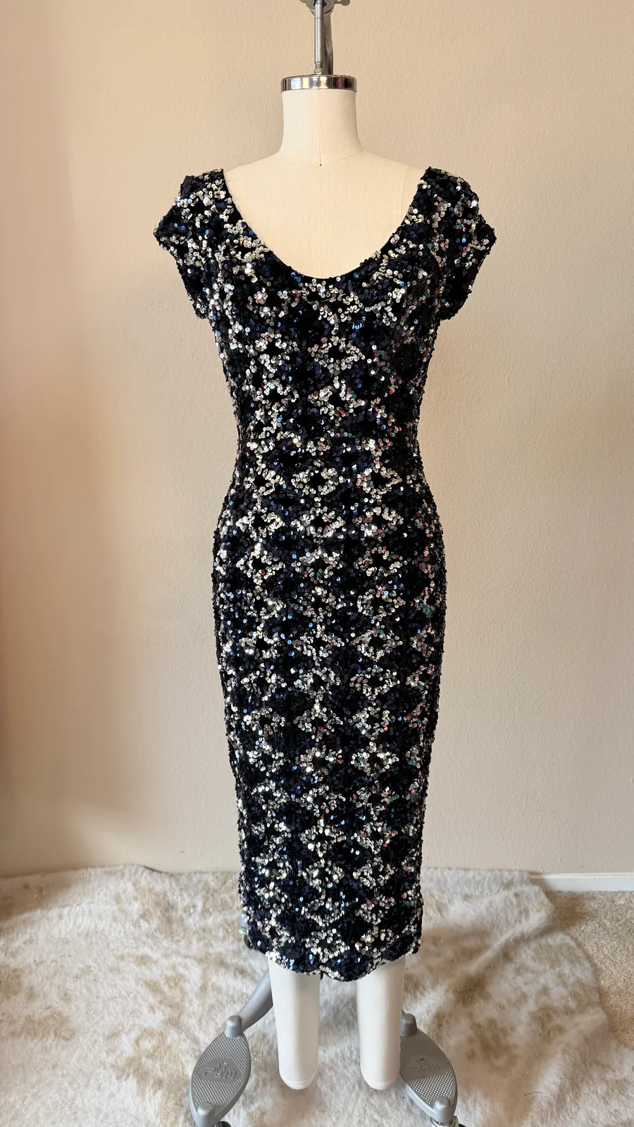 Black floral dress on a mannequin against a plain background