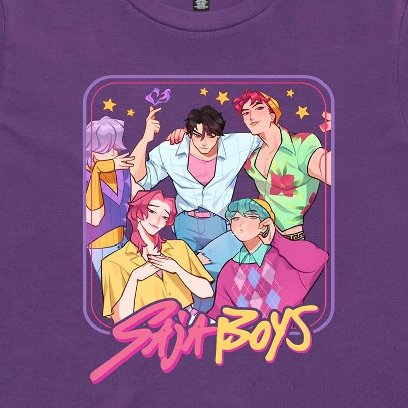 A close-up of a purple t-shirt featuring a colorful graphic print of five anime-style boys with the text 'Stunt Boys' written in a pink and yellow font below them.