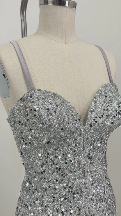 A close-up of a silver sequined strap dress displayed on a beige fabric mannequin torso against a plain light background.