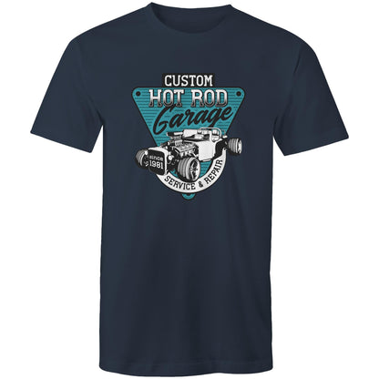 t-shirt featuring a large graphic print on the chest. The graphic is a teal and black triangular badge with the text 'CUSTOM HOT ROD Garage' and 'SERVICE & REPAIR since 1981', surrounding an illustration of a classic hot rod car with an exposed engine elements