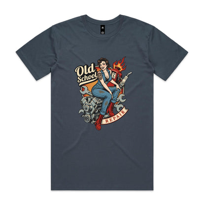 A vintage-style pin-up illustration printed on a white garment, showing a woman in blue overalls and red boots sitting on a motorcycle engine with wrenches, a gas pump, flames, and the words 'Old School' and 'REPAIR'.