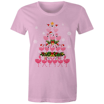 A black t-shirt featuring a festive Christmas graphic of pink flamingos stacked in the shape of a Christmas tree, wearing red Santa hats, with a green wreath, gold bells, and white snowflakes on a black background.