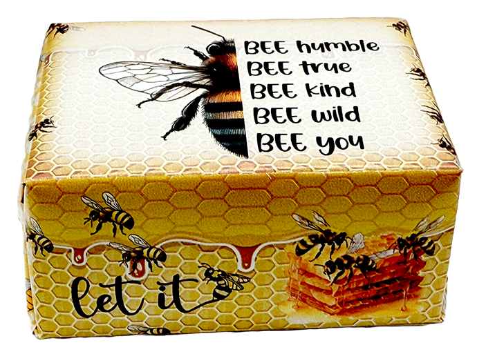 A rectangular decorative box with a honeycomb and bee design, featuring the text 'BEE humble BEE true BEE kind BEE wild BEE you' and 'let it' with a honeycomb and honeycomb pattern. The box is photographed on a plain white background.