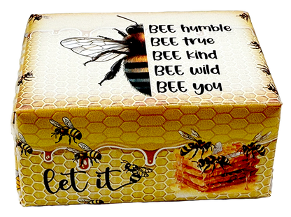 A rectangular decorative box with a honeycomb and bee design, featuring the text 'BEE humble BEE true BEE kind BEE wild BEE you' and 'let it' with a honeycomb and honeycomb pattern. The box is photographed on a plain white background.