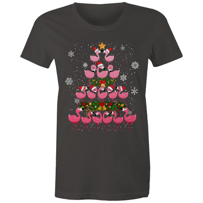 A black t-shirt featuring a festive Christmas graphic of pink flamingos stacked in the shape of a Christmas tree, wearing red Santa hats, with a green wreath, gold bells, and white snowflakes on a black background.