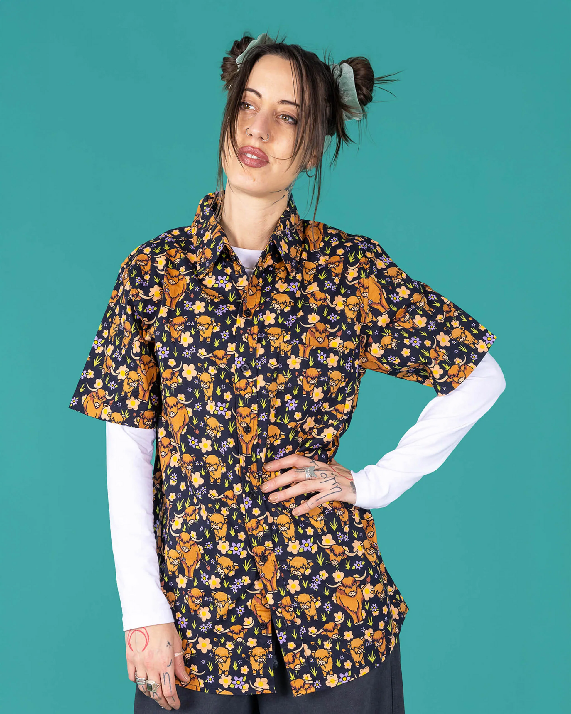 Woman wearing a floral patterned shirt against a teal background