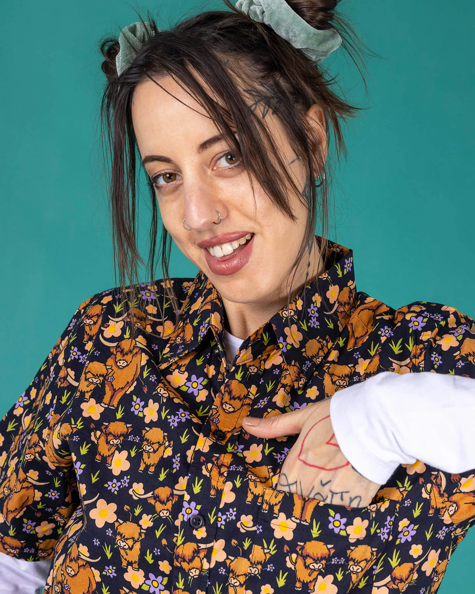 Person wearing a colorful patterned jacket against a teal background