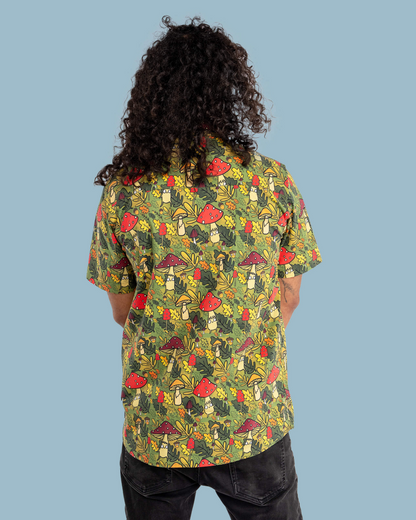 Person wearing a colorful mushroom pattern shirt on a blue background