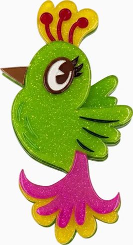 A glittery green cartoon bird charm or pin with a yellow and red crest on top, a brown beak, black eye detail, and a pink and yellow tail, shown on a plain white background.