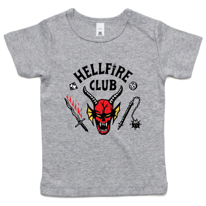 A close-up of a heather gray t-shirt featuring a graphic print with the text 'HELLFIRE CLUB' in black. Below the text is a red horned devil face with yellow wings, flanked by a black-and-red sword on the left and a black spiked chain weapon on the right.