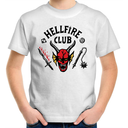 A close-up of a white t-shirt featuring a graphic print with the text 'HELL FIRE CLUB' in black arched lettering. Below the text is a red horned demon skull with yellow accents, flanked by a black sword with red flames, a black mace, and dice icons.